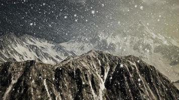 Starker Schneefall, konzentriert auf die Schneeflocken, Berge im Hintergrund video