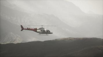 extreme slow motion vliegende helikopter in de buurt van bergen met mist video