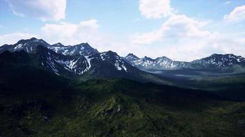 sonnige Landschaft mit Blick auf schneebedeckte Berge und Wiesen video