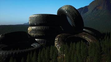 concept of environmental pollution with big old tires in mountain forest
