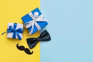 Happy Father's Day. Top view of gifts boxes, bow tie, false mustache and copy space. Father's Day celebration concept photo