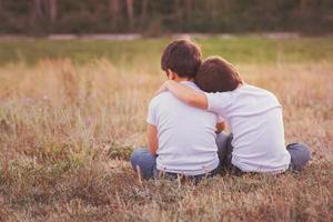 Brothers embraced sitting in the field photo