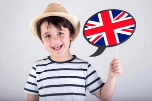 niño sonriente sosteniendo un cartel con la bandera inglesa foto