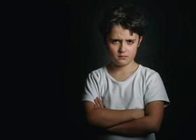 angry child on black background photo