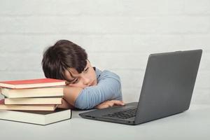 sad boy with laptop computer and books photo