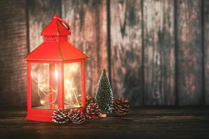 feliz navidad.fondo del concepto de navidad.linterna de navidad roja con árbol de navidad y piñas foto
