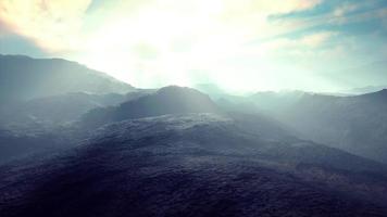 svart vulkaniskt damm och berg med dimma i bakgrunden video