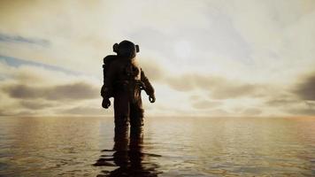 Raumfahrer im Meer unter Wolken bei Sonnenuntergang video