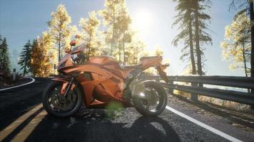 sportbike on tre road in forest with sun beams video