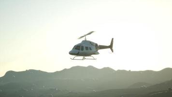 Helicóptero volador en cámara lenta extrema de 8k y cielo al atardecer video