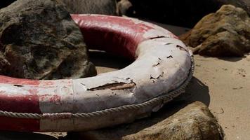 Old damaged lifebuoy on sand video