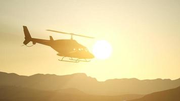 Helicóptero volador en cámara lenta extrema y cielo al atardecer video