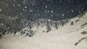 Heavy snowing, focused on the snowflakes, mountains in the background video