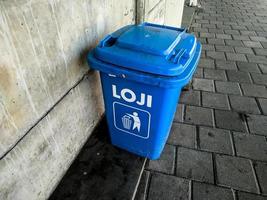 blue trash can on the sidewalk photo