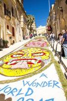 Colorful mosaic flowers drawing carpet on street near the old medieval Cittadella tower castle