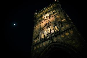 Crescent moon in evening sky over night Prague Old Town Bridge Tower