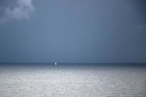 Small white sailing yacht on horizon in Gulf of Finland, Baltic sea