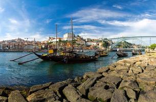 portugal, paisaje de la ciudad de porto, un grupo de botes de madera amarillos con barriles de vino en el río douro foto