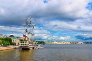 Sailboat ship with mast and russian flag moored anchored on water of Neva river in Saint Petersburg photo