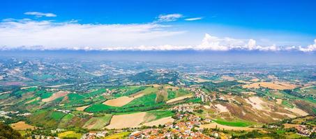 Aerial top panoramic view of landscape with valley, green hills, fields and villages of Republic San Marino photo