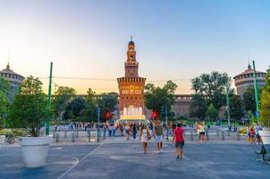 milán, italia, hileras de personas caminan en la plaza cerca de la fuente foto