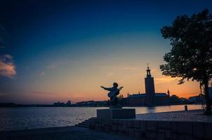 silueta del monumento de la estatua de evert taube y el consejo municipal de stadshuset del ayuntamiento en la isla de kungsholmen foto