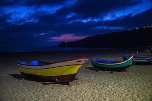 Portugal, Nazare beach, colored wooden boats, panoramic view of Nazare Town, Traditional Portuguese fishing boats photo