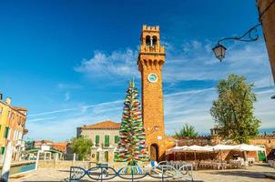 torre del reloj de murano torre dell'orologio de la iglesia de san stefano, colorido árbol de navidad hecho de cristal de murano foto