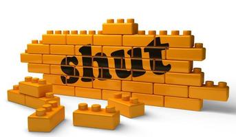 shut word on yellow brick wall photo