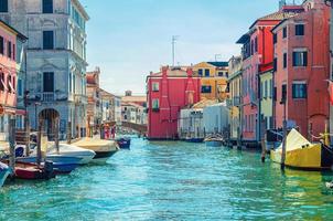 Chioggia cityscape with narrow water canal Vena with moored multicolored boats photo