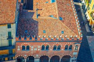 vista superior del edificio medieval de la casa domus mercatorum con almenas y techo de tejas rojas foto