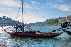 Portugal, city landscape Porto, wooden boats with wine port barrels close up on Douro river photo