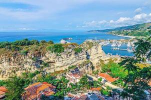 Tropea town aerial view of port marina, stone rocks and cliffs and Tyrrhenian sea with turquoise water photo