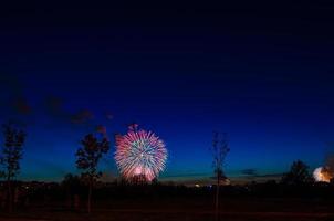 Brightly colorful firework in dark blue evening sky photo