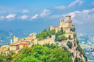 Republic San Marino Prima Torre Guaita first fortress tower with brick walls on Mount Titano stone rock with green trees photo