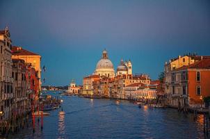 Venice cityscape with Grand Canal waterway. Buildings with evening lights along Grand Canal photo
