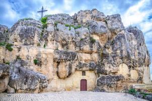 iglesia católica de santa maria de idris en roca con gran cruz en el centro histórico de la antigua ciudad antigua sassi di matera foto