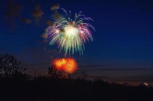 Brightly colorful firework in dark blue evening sky photo