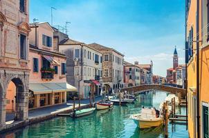 Chioggia cityscape with narrow water canal Vena with moored multicolored boats photo