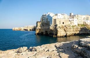 White buildings on grottos and cliffs in the town of Polignano a mare in Puglia photo