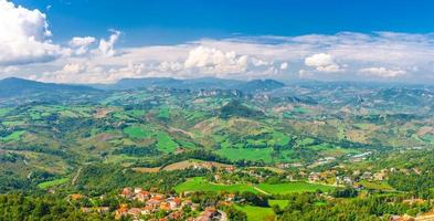 Aerial top panoramic view of landscape with valley, green hills, fields and villages of Republic San Marino photo