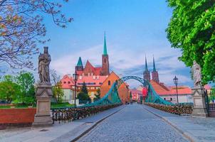 Cobblestone road and Tumski bridge over Odra Oder river, Collegiate Church of Holy Cross photo