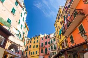 Multicolored colorful buildings houses with balconies and shutter windows on narrow street of Riomaggiore typical traditional fishing village National park Cinque Terre, below view, Liguria, Italy photo