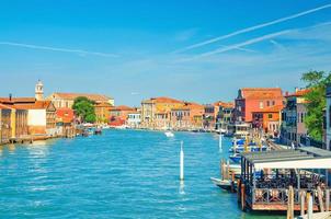 Murano islands water canal with Santa Maria degli Angeli church, boats and motor boats, Venetian Lagoon photo
