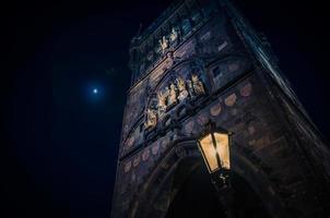Crescent moon in evening sky over night Prague Old Town Bridge Tower