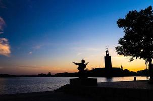 silueta de la estatua de evert taube y el ayuntamiento de estocolmo, suecia foto