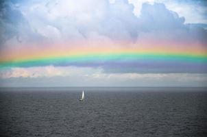 Small white sailing yacht and rainbow in Gulf of Finland, Baltic sea photo