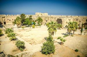 Courtyard of medieval fortress castle with palms trees in Kyrenia photo