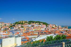 Lisbon cityscape, aerial panoramic view of Lisboa historical city centre with colorful buildings red tiled roofs, Sao Jorge Castle photo