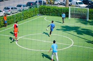 Young african boys men are playing football on sports court ground photo